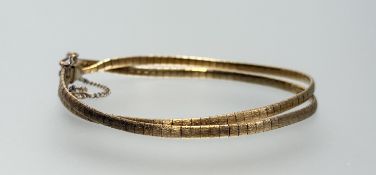 An 18ct gold twin strand snakelink bracelet on a box clasp stamped 
