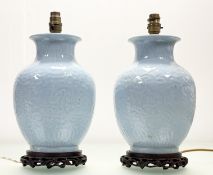 A pair of Chinese celadon-glazed baluster form table lamps, with moulded decoration, each on an
