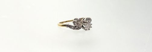 A two-stone diamond ring, the round brilliant-cut stones claw-set in a crossover setting, on