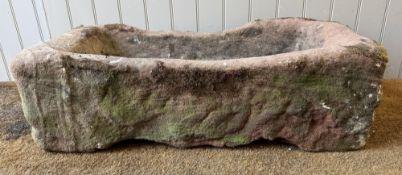A carved red sandstone rustic garden trough. 27cm by 89cm by 44cm.