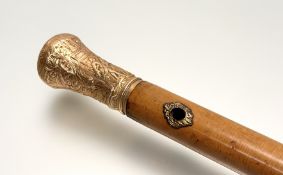 A 19th century yellow-metal mounted malacca cane, the handle repousse in the Rococo Revival style