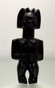 An African carved wooden figure of a standing woman, possibly Senufo, Ivory Coast, with elaborated