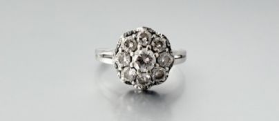 A diamond cluster ring, the central round brilliant-cut stone within a band of eight uniform round