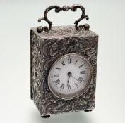 An Edwardian silver-cased dressing table or travel clock, the case with scroll-cast swing handle,