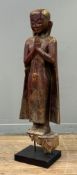 A large South-East Asian painted and parcel-gilt wooden figure of a standing Buddha, his hands