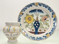 A Delft charger, mid-18th century, polychrome painted to the well with flowerheads flanking a willow