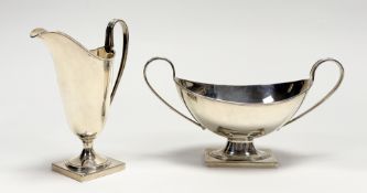 A George VI Birmingham silver two piece part tea set, comprising a helmet shaped cream jug on square