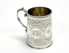 A Victorian Birmingham silver gilt tapered christening mug with a scroll handle engraved with