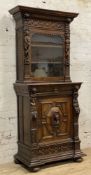 A 19th century Continental carved oak cabinet, possibly Flemish, moulded cornice with carved lion