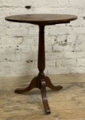 A hardwood George III-style tripod table, oval top raised on carved column support and splayed