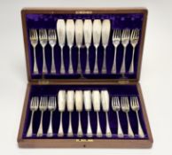 An Edwardian walnut case containing a set of twelve pairs of epns foliate engraved fish knives: l. x