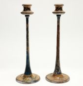 A pair of folk-art style wooden candlesticks of tapered form raised on circular base, with hand-
