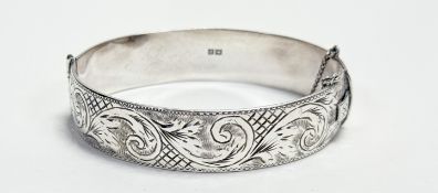 A Queen Elizabeth II Birmingham silver cast stiff hinged bangle with engraved decoration and
