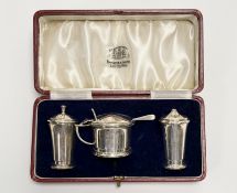 A George V Birmingham silver three piece tapered condiment set on circular bases in the Art Deco
