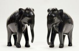 A pair of African ebonised carved wooden elephant figures. (h-15cm) (a/f) (2)