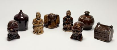 A collection of eight treacle glazed late 19thc Scottish Pottery Moneybanks, two in the form