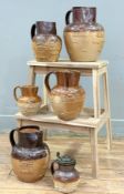 A group of six varying sized salt-glazed stoneware pitchers, each with moulded figural scenes /