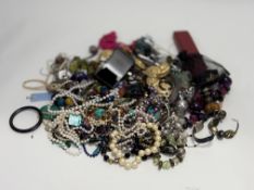 A large collection of costume jewellery to include paste pearl and metal necklaces, bracelets, two