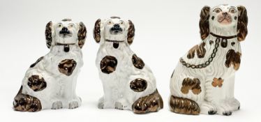 A pair of Chimney Spaniels, decorated in a spotting brown lustre glaze with padlock collar (crack to