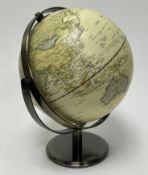 A contemporary terrestrial table globe with a printed map on a cream ground, raised on a brushed