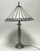 A modern Tiffany-style table lamp with iridescent white cone shade and clear gem details, raised