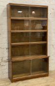 A mid-century sectional bookcase by Minty of Oxford, in five sections, each with twin sliding glazed