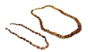 A dark honey coloured amber graduated rounded thong necklace with ring fastening: l. x 33cm