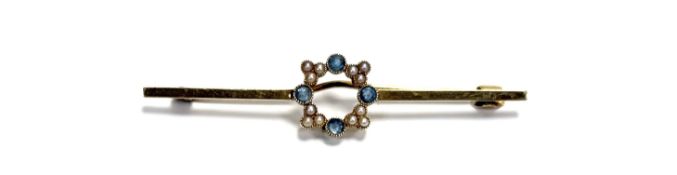 An Edwaridian 15ct gold bar brooch with open circular panel set four circular facet cut