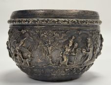A Thai white metal chased bowl with panels depicting dancing and fighting figures within scrolling