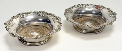 A pair of late Victorian Sheffield plated wine slides with chased cast foliate scalloped borders and