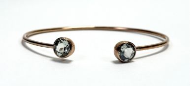 A 9ct rose gold open bangle with inset faceted stone terminals: d. x 7cm 10.8g