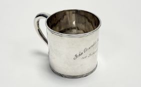 A George V Birmingham silver christening mug of plain cylindrical form with s scroll handle engraved