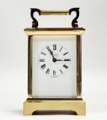 A modern James Jewellers of Edinburgh brass four glass clock with white enamel dial and roman