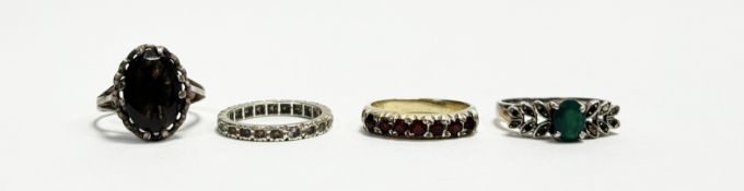 A collection of four silver rings to include an oval facet cut cairngorm ring O, a ring set seven