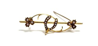 An Edwardian 15ct gold bar brooch set with wishbone and three-leaf clover set seed pearls: l. x 4.