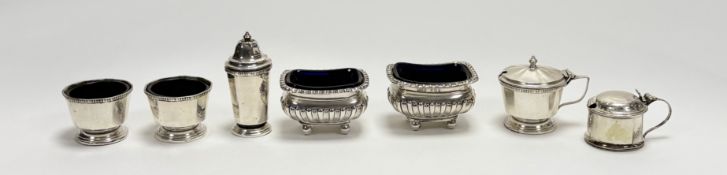 A pair of George V Sheffield silver salt sellers of half lobbed design with Bristol blue glass