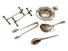 Group of silver to include a tea strainer, Edwardian caddy spoon, pair of sugar tongs, coffee spoon