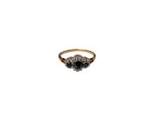 Sapphire and diamond ring with three round mixed cut blue sapphires surrounded by a border of diamon