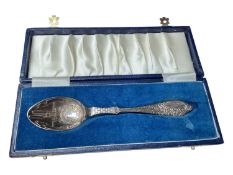 Silver christening spoon with clock decoration to the bowl and a stork carrying a baby to the handle