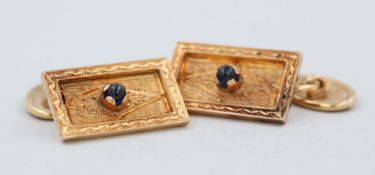 Paar Manschettenknöpfe, 14 kt Gelbgold, mit je 1 kleinen Saphir Cabochon, fein verziert, ca. 6,7