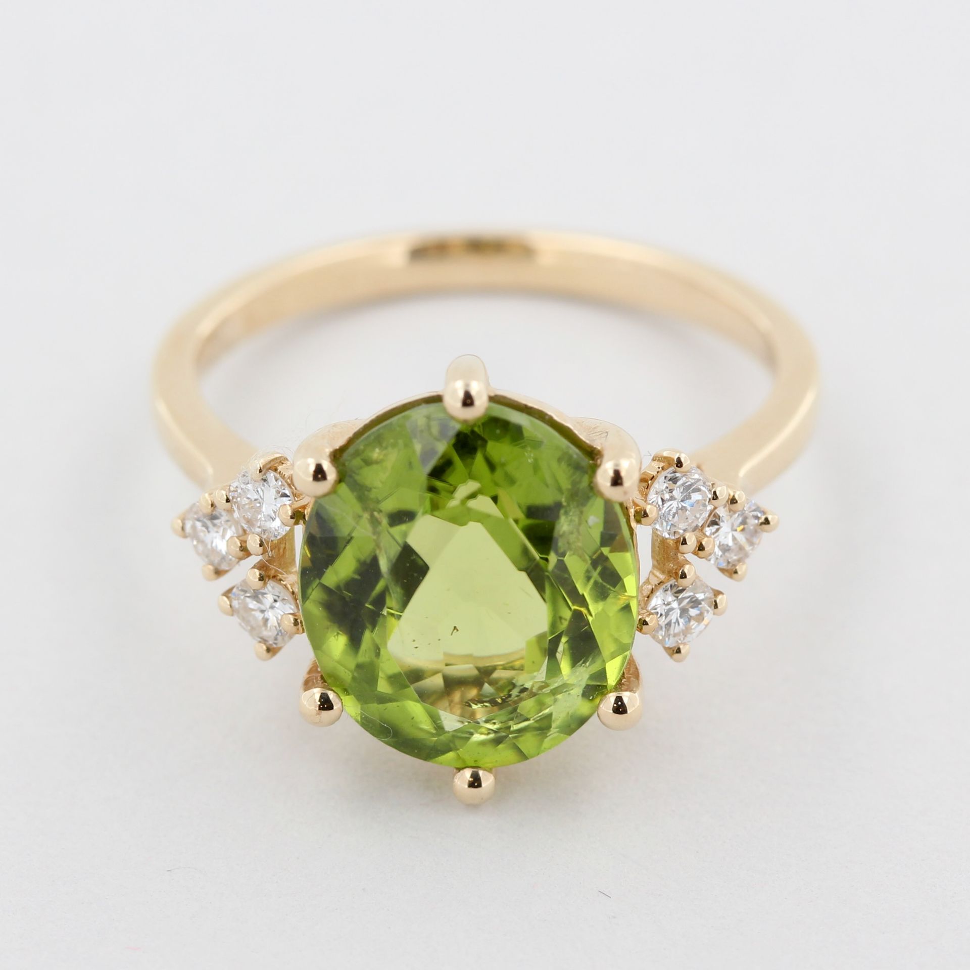 Damenring, 14 kt Gelbgold, mit 1 ovalen Peridot, ca. 4,80 ct, 6 Brillanten als Besatz, ca. 4,8 g, RM