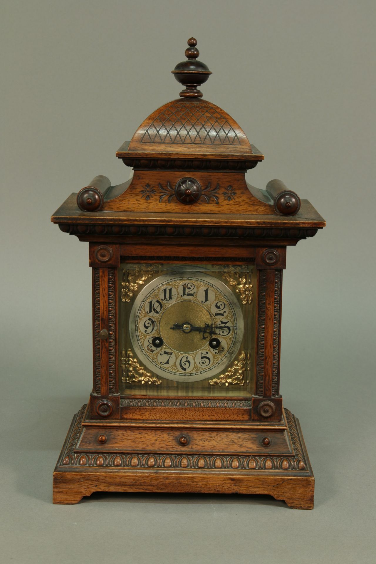 Tischuhr, 20. Jh., England, Nussbaumgehäuse, reichlich verziert, Pagodendach, Messing Zifferblatt,