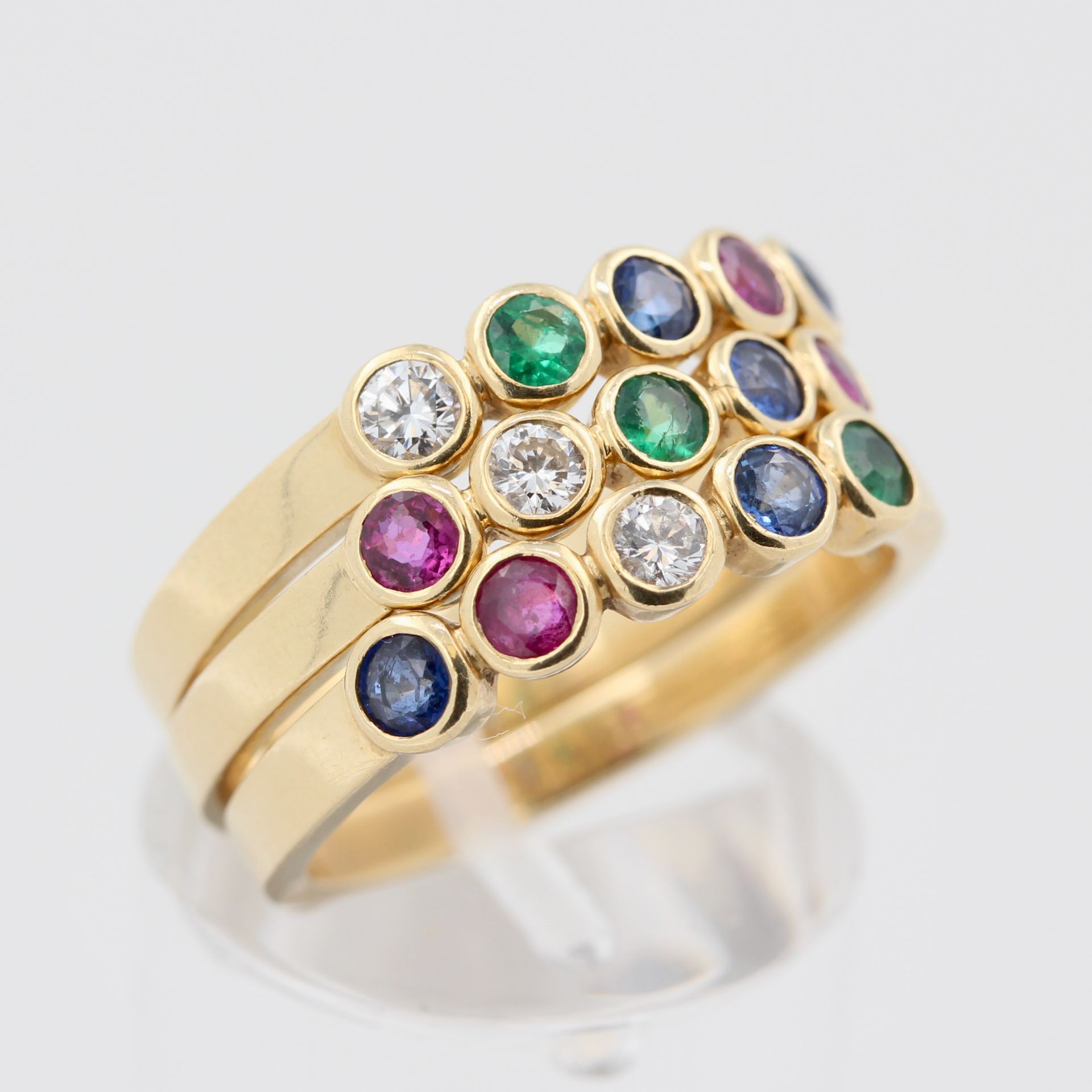Set Damenringe, 18 kt Gelbgold, mit Brillanten, Saphiren, Smaragden und Rubinen, punziert, ca. 10,