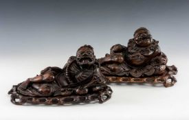 TWO CARVED HARDWOOD MYTHICAL FIGURES, with glass eyes, depicting Liu Hai with string of cash and