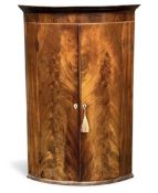 GOOD GEORGIAN FLAME MAHOGANY BOW FRONT HANGING CORNER CUPBOARD c.1800, with two doors, 112 (h) x