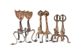 THREE PAIRS OF ARTS & CRAFTS PERIOD COPPER FIRE DOGS, including pair with shield shaped terminals