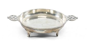 GEORGE V CIRCULAR SILVER QUAICH with pierced handles, on four scroll feet, Birmingham 1921, 9cms (