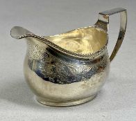 GEORGIAN CREAM JUG, presumed silver, with gadrooned rim and chased body, inscribed on base '24th May