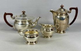 FOUR-PIECE SILVER TEA SERVICE of circular form, bead rim, teapot and hot water jug with wooden