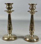 PAIR OF GEORGE V SILVER CANDLESTICKS of circular form, acanthus leaf motifs to the stems, loaded